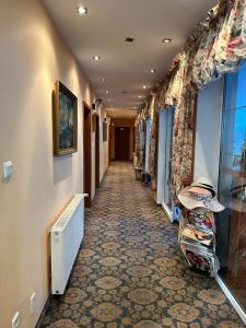 a hallway in a hotel with a tile floor at Pensjonat Perła in Pobierowo