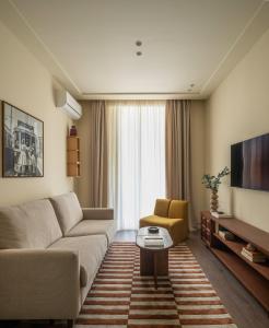 a living room with a couch and a tv at POSTCODE Chueca in Madrid
