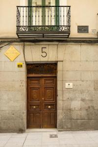 a building with a large wooden door with a balcony at POSTCODE Chueca in Madrid