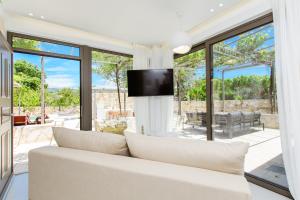 a living room with a white couch and large windows at Archontiki Elite Villa - Private Pool, Chania in Vryses