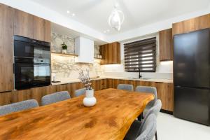 a kitchen and dining room with a wooden table and chairs at Archontiki Elite Villa - Private Pool, Chania in Vryses