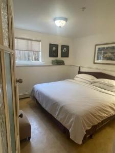 a bedroom with a large bed and a window at Manor guesthouse in Vancouver