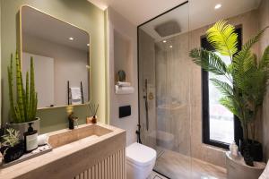 a bathroom with a sink and a toilet and a mirror at Contessa Suites in Lefkada +145 photos