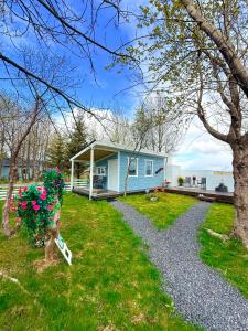 a blue house with a pathway leading to a yard at Baksas Luxury Campers in Selfoss