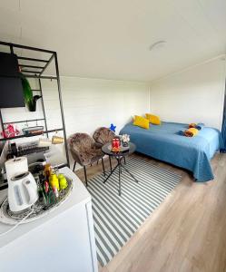 a bedroom with a bed and a table and a kitchen at Baksas Luxury Campers in Selfoss