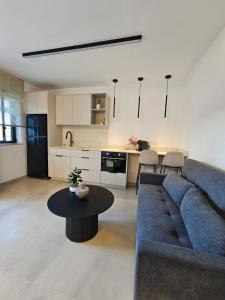 ein Wohnzimmer mit einem blauen Sofa und einem Tisch in der Unterkunft מנות בטבע in Manot