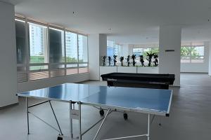 a ping pong table in a room with a piano at Ocean Club by Colproperty Management in Playa Bello Horizonte