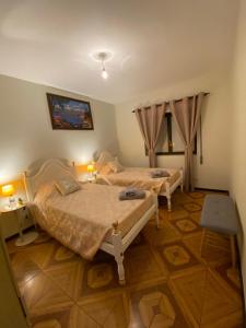 a bedroom with two beds and two windows at Meira House in Belinho