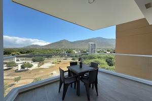 a dining room with a table and chairs on a balcony at Ocean Club by Colproperty Management in Playa Bello Horizonte