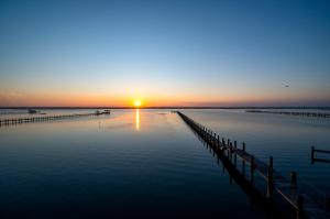 a sunset over a body of water with a dock at Paradise in Chincoteague