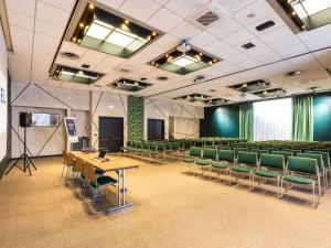 a conference room with green chairs and a podium at Novotel Genova City in Genoa +131 photos
