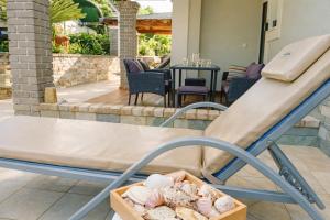 a slide in a playground with a box of rocks at Villa Nirvana - Sea View Maisonette in Roda, Offering Tranquility and Comfort on the Enchanting Northern Coast of Corfu in (( Litherés ))