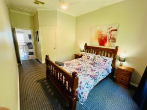 a bedroom with a bed with a wooden frame at Treetops Escape Albury in Albury