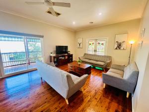 a living room with two couches and a tv at Treetops Escape Albury in Albury