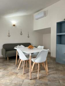a dining room with a white table and white chairs at House Mimma Tropea in Santa Domenica