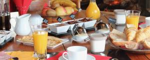 a table topped with breakfast foods and orange juice at Le Clos Ker'hadenn, chambres d'hôtes à Saint-Pierre Quiberon, à deux pas de la plage in Saint-Pierre-Quiberon