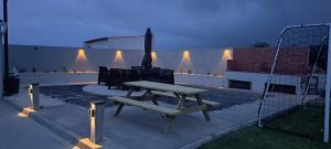 a picnic table and chairs on a patio at night at 3BL Retreat - Escape & Poolparty in Praia da Vitória