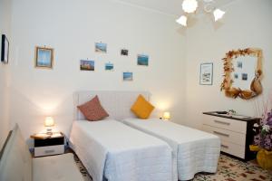 a bedroom with a bed and a dresser with two lamps at La Casa di Baldo in Ugento