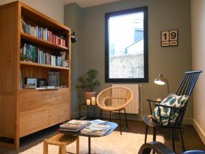 a living room with two chairs and a book shelf at Hotel de France in Saint-Pol-de-Léon