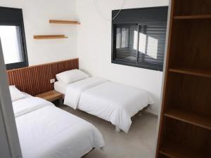 ein Zimmer mit zwei Betten und einem Fenster in der Unterkunft וילה Mandala אירוח&אירועים in Sājūr + 21 Fotos