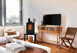 a living room with a bed and a flat screen tv at TAGA Rooms in Catania