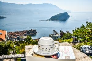 una taza de té sobre una mesa con vistas al océano en Studios Kalina, en Budva