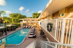 an exterior view of a hotel with a swimming pool at Sheridan Suites Apartments in Dania Beach