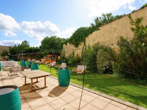 a patio with a table and chairs in a garden at Mercure Bordeaux Chateau Chartrons in Bordeaux
