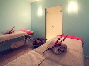 a room with two beds and a mirror at Mercure Saint Nectaire - Spa & Bien-Être in Saint-Nectaire