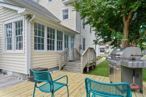 a backyard with two chairs and a grill on a deck at Precious Time in Chincoteague
