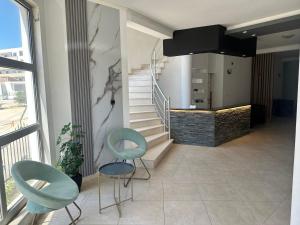 a living room with two chairs and a staircase at STANDART Premium in Ulcinj