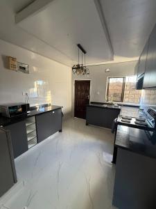 a large kitchen with black and white counter tops at Central place in Lusaka