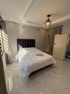 a bedroom with a large white bed in a room at Central place in Lusaka