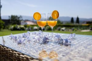two glasses of orange juice sitting on a table at Quarto em Viana do Castelo in Viana do Castelo