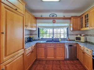 a kitchen with wooden cabinets and a sink and a window at Suite em Viana do Castelo in Viana do Castelo