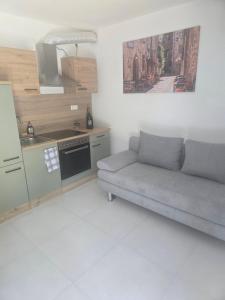 a living room with a couch and a kitchen at La Piccola Italia in Deggingen