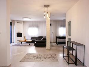 ein Wohnzimmer mit Sofa und Tisch in der Unterkunft וילה Mandala אירוח&אירועים in Sājūr