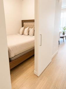 a bedroom with a bed in a white room at Lovely Brand New Suite in Sidney