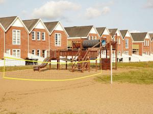a playground with a slide in front of a building at 6 person holiday home in Rømø-By Traum in Sønderby