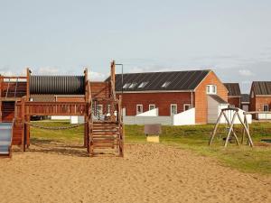 a playground in front of a house and a building at 6 person holiday home in Rømø-By Traum in Sønderby +27 photos