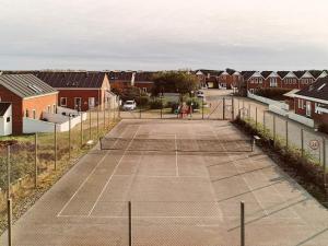 a tennis court with two people playing on it at 6 person holiday home in Rømø-By Traum in Sønderby