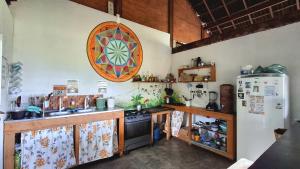 a kitchen with a stove and a refrigerator at Kombi Hostel Camping in Vale do Capao