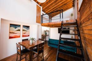 a room with a dining table and a loft bed at Primario Hotel Boutique in Ensenada
