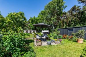 a patio with an umbrella and chairs in a yard at Boutique Hotel Villa Wahnfried Thiessow in Thiessow