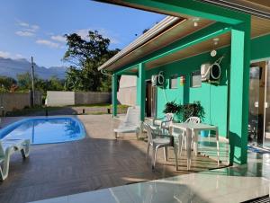 a patio with a table and chairs next to a swimming pool at Reino Encantado Dona Siroba in Morretes