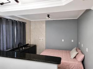 a small bedroom with a bed and a sink at Casa Aconchegante com Espaço Gourmet in Itatiba