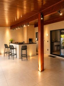 a kitchen with chairs and a bar in a room at Casa Aconchegante com Espaço Gourmet in Itatiba +11 photos