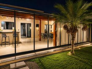 a house with a palm tree in the yard at Casa Aconchegante com Espaço Gourmet in Itatiba
