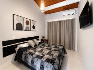 a bedroom with a black and white bed and a tv at Paúba Beach Hotel in Pauba +18 photos