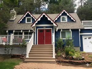 a blue house with a red door and stairs at Serenity Woods - Game Room & More in South Lake Tahoe